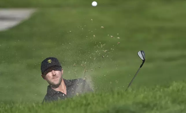 International team member Mackenzie Hughes, of Canada, hits out of a bunker on the fifth hole during a fifth-round singles match at the Presidents Cup golf tournament at Royal Montreal Golf Club, Sunday, Sept. 29, 2024, in Montreal. (Christinne Muschi/The Canadian Press via AP)