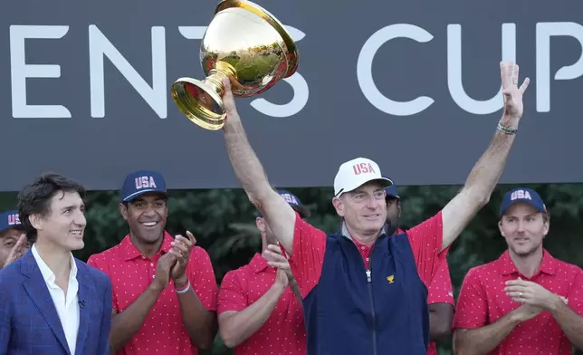 United States team captain Jim Furyk hoist the Presidents Cup as Canada Prime Minister Justin Trudeau looks on at Royal Montreal Golf Club on Sunday, Sept. 29, 2024, in Montreal. (Frank Gunn/The Canadian Press via AP)