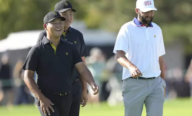 International team member Si Woo Kim, of South Korea, left, walks with partner Byeong Hun An, of South Korea, and United States team member Scottie Scheffler down the eighth fairway during the second round of the Presidents Cup golf tournament at Royal Montreal Golf Club in Montreal, Friday, Sept. 27, 2024. (Nathan Denette/The Canadian Press via AP)