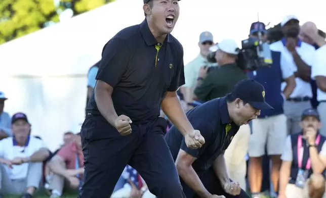 International team member Si Woo Kim, left, and celebrates with partner Byeong Hun An, after sinking the winning putt on the 18th hole during a second round foursome match at the Presidents Cup golf tournament at Royal Montreal Golf Club Friday, Sep.27, 2024 in Montreal. (Frank Gunn/The Canadian Press via AP)