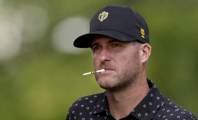 International team member Taylor Pendrith, of Canada, holds a tee in his mouth on the 14th hole during a first-round four-ball match at the Presidents Cup golf tournament at the Royal Montreal Golf Club in Montreal, Thursday, Sept. 26, 2024. (Nathan Denette/The Canadian Press via AP)