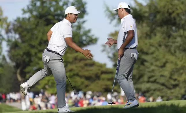 International team member Si Woo Kim, right, of South Korea, celebrates with partner Tom Kim, left, also of South Korea, after a birdie putt on the fifth hole during a fourth-round foursomes match at the Presidents Cup golf tournament at Royal Montreal Golf Club in Montreal, Saturday, Sept. 28, 2024. (NathanDenette/The Canadian Press via AP)