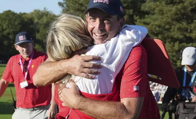 United States team member Keegan Bradley, right, hugs his wife Jillian Stacey after winning the Presidents Cup golf tournament at Royal Montreal Golf Club, Sunday, Sept. 29, 2024, in Montreal. (Nathan Denette/The Canadian Press via AP)