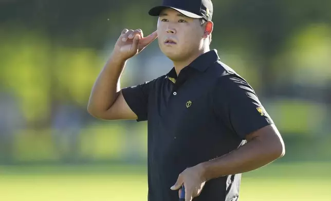 International team member Si Woo Kim, of South Korea, listens to applause after making a putt on the 16th hole during a second-round foursome match at the Presidents Cup golf tournament at Royal Montreal Golf Club, Friday, Sept. 27, 2024 in Montreal. (Nathan Denette/The Canadian Press via AP)