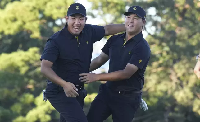 International team member Si Woo Kim of South Korea, celebrates with partner International team member Byeong Hun An of South Korea, after sinking the winning putt on the 18th hole during second round foursome match at the Presidents Cup golf tournament at Royal Montreal Golf Club, Friday, Sept. 27, 2024 in Montreal. (Nathan Denette/The Canadian Press via AP)