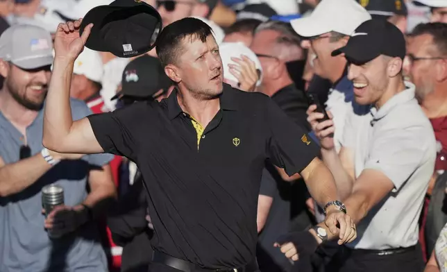 International team member Mackenzie Hughes of Canada, pumps up the crowd on the 16th hole during second round foursome match at the Presidents Cup golf tournament at Royal Montreal Golf Club Friday, Sept. 27, 2024 in Montreal. (Nathan Denette/The Canadian Press via AP)