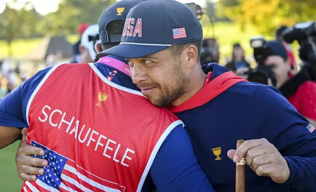 United States team member Xander Schauffele, right, celebrates with caddie Austin Kaiser, left, following the U.S. win over the International Team at the Presidents Cup at Royal Montreal Golf Club in Montreal, Sunday, Sept. 29, 2024. (Graham Hughes/The Canadian Press via AP)