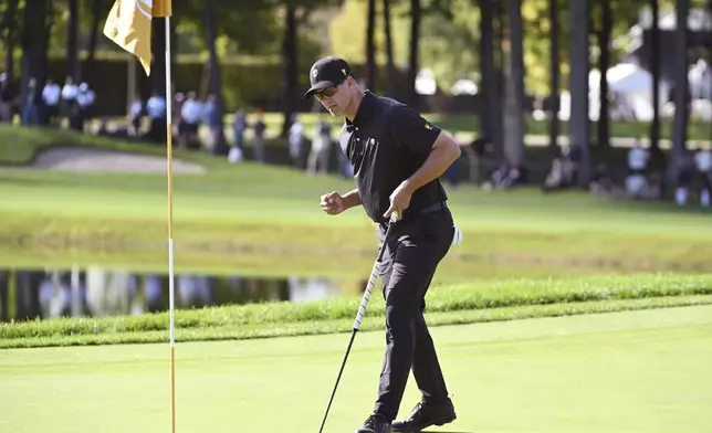 International team member Adam Scott of Australia, makes a putt on the 10th green during a foursome match at the Presidents Cup golf tournament at the Royal Montreal Golf Club in Montreal, Friday, Sept. 27, 2024. (Graham Hughes/The Canadian Press via AP)