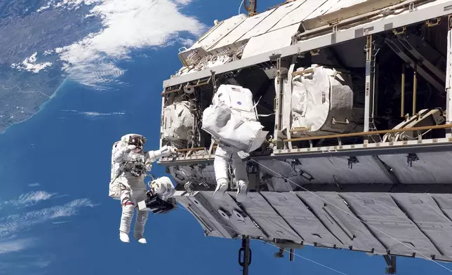 FILE - In this photo provided by NASA, astronaut Robert L. Curbeam Jr., left, and European Space Agency astronaut Christer Fuglesang, participate in a spacewalk during construction of the International Space Station on Dec. 12, 2006. In the background are New Zealand and the Pacific Ocean. (NASA via AP, File)