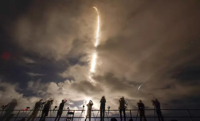 A time exposure shows photographers as they document the SpaceX Falcon 9 rocket with a crew of four as it launches from pad 39A at the Kennedy Space Center in Cape Canaveral, Fla., Monday, Sept. 9, 2024. (AP Photo/John Raoux)