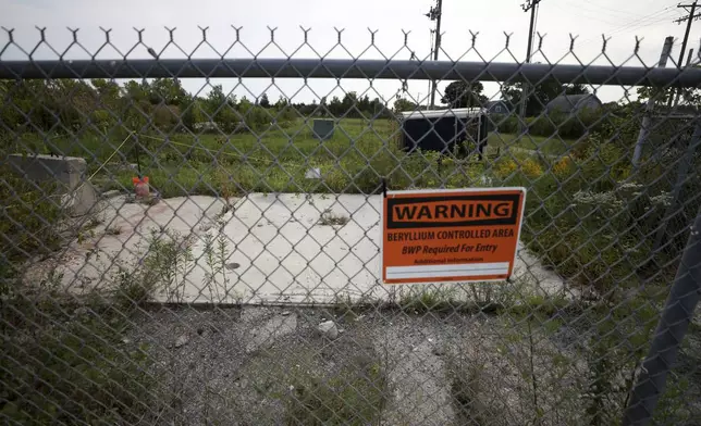 A sign warning of beryllium hangs on a fence at the Luckey FUSRAP (Formerly Utilized Sites Remedial Action Program) site, which was designated as such due to beryllium contamination, in Luckey, Ohio, Wednesday, Sept. 11, 2024. (Kurt Steiss /The Blade via AP)