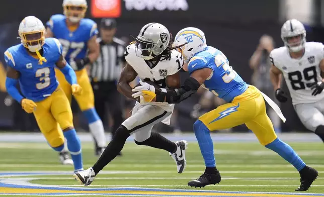 Las Vegas Raiders wide receiver Davante Adams, middle, runs against Los Angeles Chargers safety Alohi Gilman (32) during the first half of an NFL football game, Sunday, Sept. 8, 2024, in Inglewood, Calif. (AP Photo/Marcio Jose Sanchez)