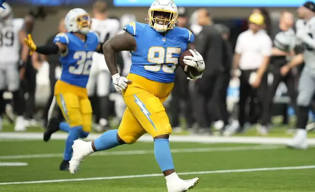 Los Angeles Chargers defensive tackle Poona Ford (95) celebrates after an interception against the Las Vegas Raiders during the second half of an NFL football game, Sunday, Sept. 8, 2024, in Inglewood, Calif. (AP Photo/Ashley Landis)