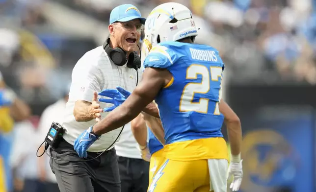 Los Angeles Chargers running back J.K. Dobbins (27) is congratulated by head coach Jim Harbaugh after scoring against the Las Vegas Raiders during the second half of an NFL football game, Sunday, Sept. 8, 2024, in Inglewood, Calif. (AP Photo/Ashley Landis)