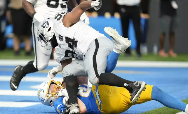 Las Vegas Raiders defensive tackle Christian Wilkins, top, falls forward over Los Angeles Chargers tight end Will Dissly as players from both teams fight during the second half of an NFL football game, Sunday, Sept. 8, 2024, in Inglewood, Calif. (AP Photo/Ashley Landis)