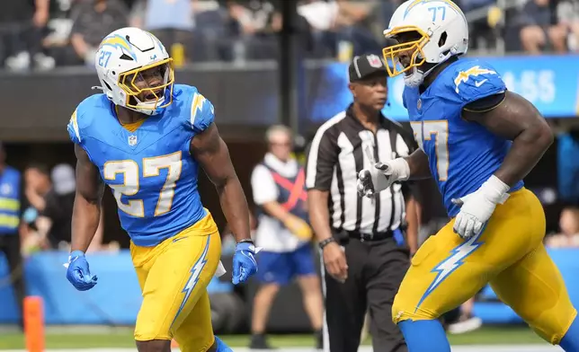 Los Angeles Chargers running back J.K. Dobbins (27) celebrates with guard Zion Johnson (77) after scoring a touchdown against the Las Vegas Raiders during the second half of an NFL football game, Sunday, Sept. 8, 2024, in Inglewood, Calif. (AP Photo/Ashley Landis)