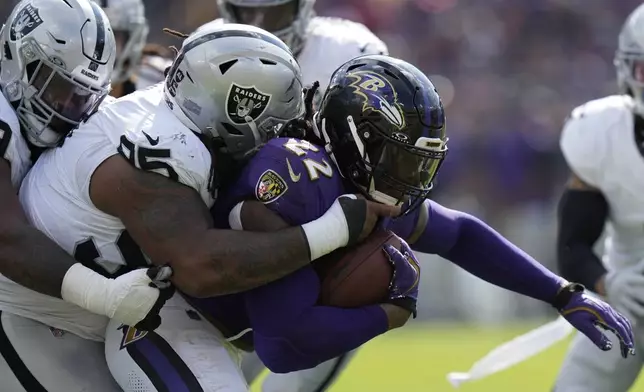 Las Vegas Raiders defensive tackle John Jenkins (95) tackles Baltimore Ravens running back Derrick Henry (22) during the second half of an NFL football game, Sunday, Sept. 15, 2024, in Baltimore. (AP Photo/Stephanie Scarbrough)