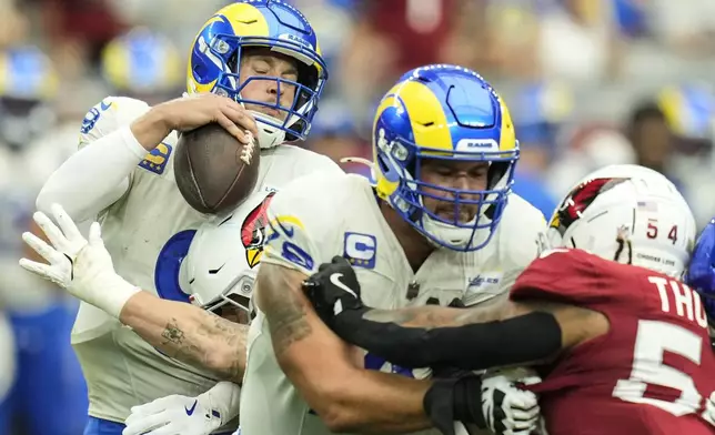 Los Angeles Rams quarterback Matthew Stafford (9) is sacked by Arizona Cardinals linebacker Dennis Gardeck (45) during the first half of an NFL football game, Sunday, Sept. 15, 2024, in Glendale, Ariz. (AP Photo/Ross D. Franklin)