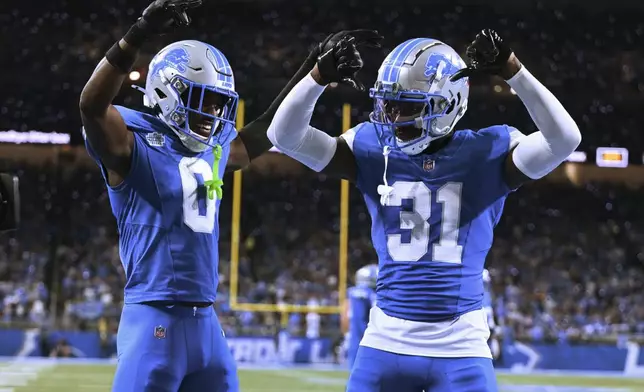 Detroit Lions safety Kerby Joseph (31) celebrates his interception with Detroit Lions cornerback Terrion Arnold (0) against the Los Angeles Rams during the first half of an NFL football game in Detroit, Sunday, Sept. 8, 2024. (AP Photo/David Dermer)