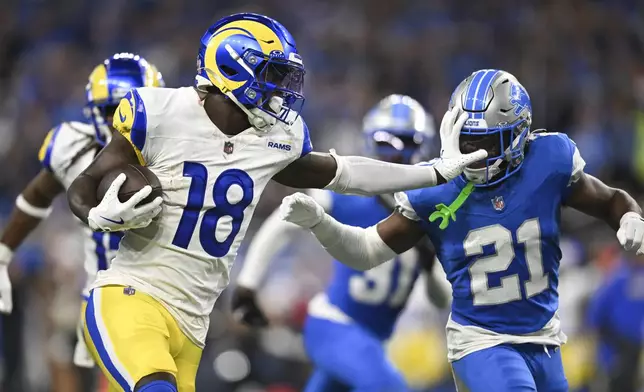 Los Angeles Rams wide receiver Tyler Johnson (18) stiff-arms Detroit Lions cornerback Amik Robertson (21) during a 63-yard reception during the second half of an NFL football game in Detroit, Sunday, Sept. 8, 2024. (AP Photo/David Dermer)