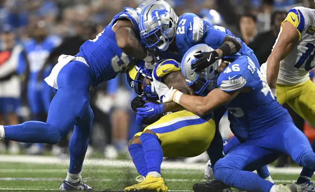 Los Angeles Rams running back Kyren Williams (23) is tackled by Detroit Lions cornerback Carlton Davis III (23) and linebacker Jack Campbell (46) during the second half of an NFL football game in Detroit, Sunday, Sept. 8, 2024. (AP Photo/David Dermer)