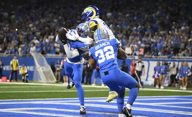 Detroit Lions safety Kerby Joseph (31) intercepts a pass intended for Los Angeles Rams wide receiver Tyler Johnson (18) in the end zone as Detroit Lions safety Brian Branch (32) looks on during the first half of an NFL football game in Detroit, Sunday, Sept. 8, 2024. (AP Photo/David Dermer)