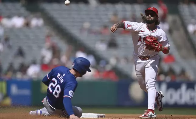 Los Angeles Angels' Jack López throws from second base as Texas Rangers' Jonah Heim is out in a double play during the fourth inning of a baseball game Sunday, Sept. 29, 2024, in Anaheim, Calif. (AP Photo/John McCoy)