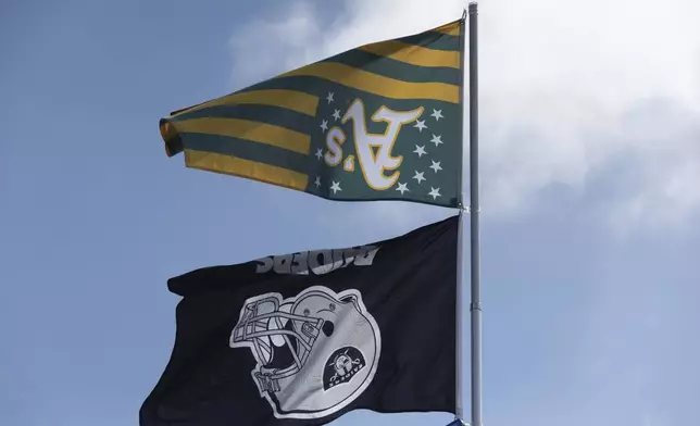 An Oakland Athletics and Raiders flags fly upside down outside the Oakland Coliseum before a baseball game between the Oakland Athletics and the Texas Rangers Thursday, Sept. 26, 2024, in Oakland, Calif. (AP Photo/Benjamin Fanjoy)