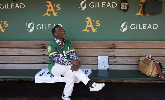 Former baseball player Rickey Henderson laughs as he sits in the dugout before a baseball game between the Oakland Athletics and the Texas Rangers, Thursday, Sept. 26, 2024, in Oakland, Calif. (AP Photo/Godofredo A. Vásquez)