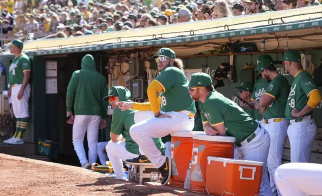 Oakland Athletics'Joey Estes (68) and Kyle McCann, center right, look on from the dugout during a baseball game against the Texas Rangers, Thursday, Sept. 26, 2024, in Oakland, Calif. (AP Photo/Godofredo A. Vásquez)