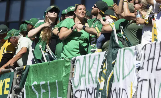 Fans react during a baseball game between the Oakland Athletics and Texas Rangers Thursday, Sept. 26, 2024, in Oakland, Calif. (AP Photo/Benjamin Fanjoy)