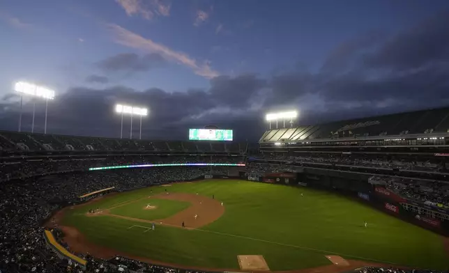 Fans at the Oakland Coliseum watch during the second inning of a baseball game between the Oakland Athletics and the Texas Rangers in Oakland, Calif., Wednesday, Sept. 25, 2024. (AP Photo/Jeff Chiu)