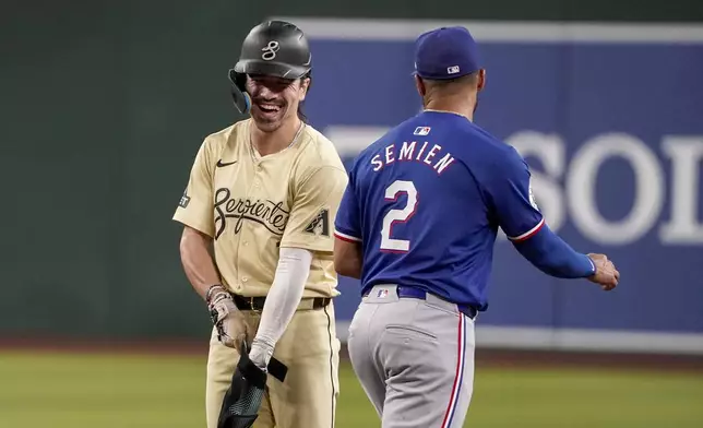 Arizona Diamondbacks' Corbin Carroll, left, shares a laugh with Texas Rangers second base Marcus Semien (2) during the fourth inning of a baseball game, Tuesday, Sept. 10, 2024, in Phoenix. (AP Photo/Darryl Webb)