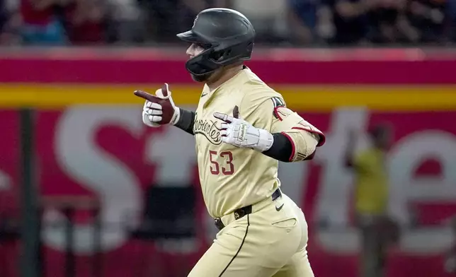 Arizona Diamondbacks' Christian Walker gestures towards his bullpen after hitting a home run against the Texas Rangers during the first inning of a baseball game, Tuesday, Sept. 10, 2024, in Phoenix. (AP Photo/Darryl Webb)