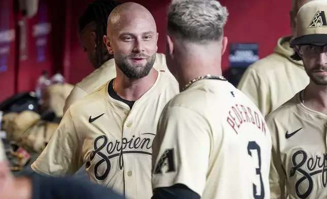 Arizona Diamondbacks' Christian Walker, left, shares a laugh with designated hitter Joc Pederson (3) after the pair hit back to back home runs against the Texas Rangers during the first inning of a baseball game, Tuesday, Sept. 10, 2024, in Phoenix. (AP Photo/Darryl Webb)