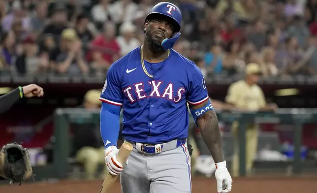 Texas Rangers' Adolis García reacts after striking out against the Arizona Diamondbacks during the fourth inning of a baseball game, Tuesday, Sept. 10, 2024, in Phoenix. (AP Photo/Darryl Webb)