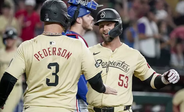 Arizona Diamondbacks' Joc Pederson (3) greets Christian Walker, right, at home plate after Walker's second home run of the game against the Texas Rangers during the third inning of a baseball game, Tuesday, Sept. 10, 2024, in Phoenix. (AP Photo/Darryl Webb)