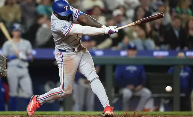 Texas Rangers' Adolis García hits into a groundout to score Josh Smith against the Seattle Mariners during the eighth inning of a baseball game Thursday, Sept. 12, 2024, in Seattle. (AP Photo/Lindsey Wasson)