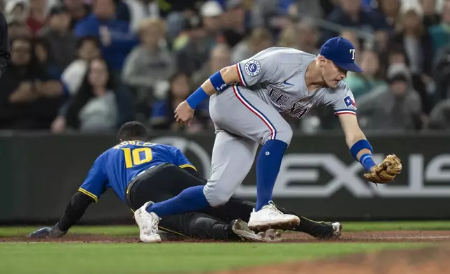 Seattle Mariners' Luke Raley steals third base against Texas Rangers third baseman Josh Jung during the seventh inning of a baseball game, Saturday, Sept. 14, 2024, in Seattle. (AP Photo/Stephen Brashear)