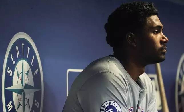 Texas Rangers starting pitcher Kumar Rocker sits in the dugout before facing the Seattle Mariners during the first inning of a baseball game Thursday, Sept. 12, 2024, in Seattle. (AP Photo/Lindsey Wasson)