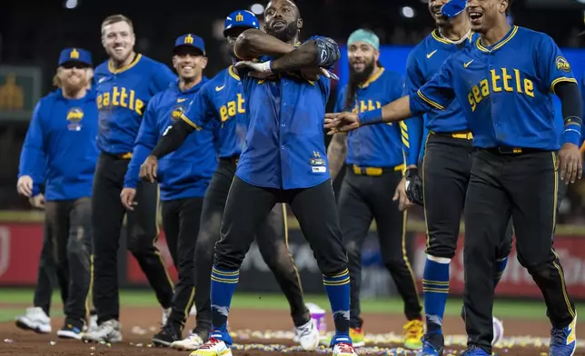 Seattle Mariners' Randy Arozarena, center, celebrates with teammates including Jorge Polanco, far right, and Julio Rodriguez, second from right, after a baseball game against the Texas Rangers, Saturday, Sept. 14, 2024, in Seattle. (AP Photo/Stephen Brashear)