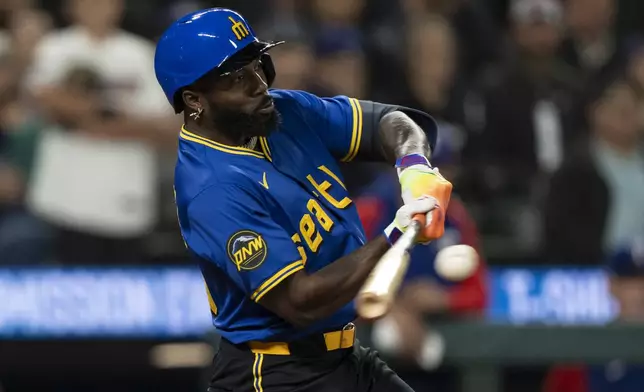 Seattle Mariners' Randy Arozarena hits a RBI single during the ninth inning of a baseball game against the Texas Rangers, Saturday, Sept. 14, 2024, in Seattle. (AP Photo/Stephen Brashear)