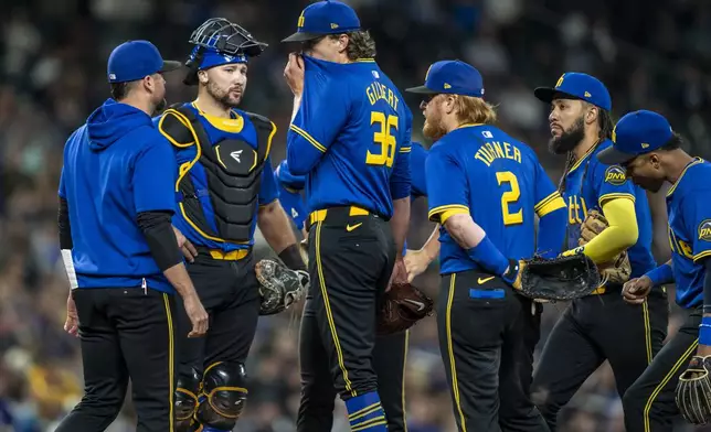 From left, Seattle Mariners pitching coach Pete Woodworth, catcher Cal Raleigh, starting pitcher Logan Gilbert, first baseman Justin Turner, shortstop J.P. Crawford and second baseman Jorge Polanco meet at the mound during the fifth inning of a baseball game against the Texas Rangers, Saturday, Sept. 14, 2024, in Seattle. (AP Photo/Stephen Brashear)