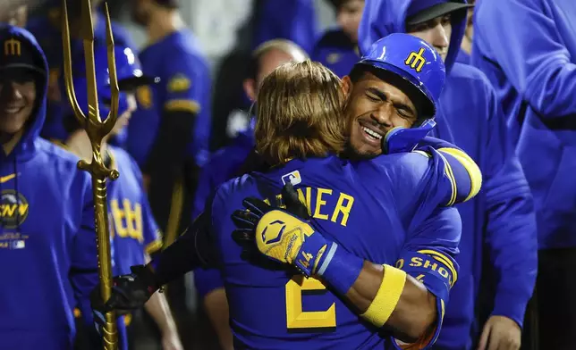 Seattle Mariners' Julio Rodriguez, right, gets a big hug from Justin Turner following his three-run homer in the eighth inning of a baseball game against the Texas Rangers, Friday, Sept. 13, 2024, in Seattle, (Dean Rutz/The Seattle Times via AP)