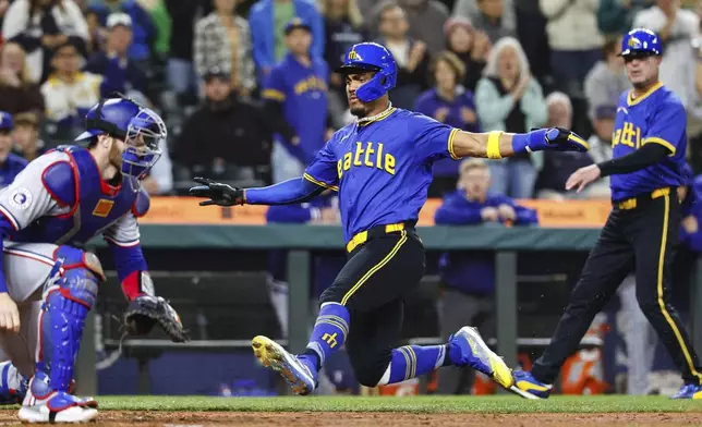 Julio Rodriguez scores on the Randy Arozarena RBI single in the seventh. The Texas Rangers played the Seattle Mariners in Major League Baseball Friday, Sept. 13, 2024 at T-Mobile Park, in Seattle. (Dean Rutz/The Seattle Times via AP)