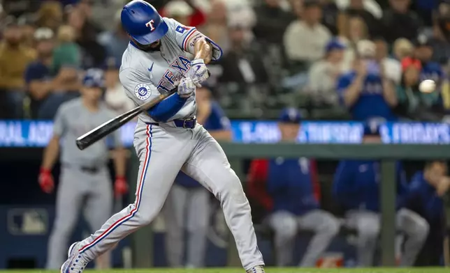 Texas Rangers' Marcus Semien hits a two-run home run during the fifth inning of a baseball game against the Seattle Mariners, Saturday, Sept. 14, 2024, in Seattle. (AP Photo/Stephen Brashear)