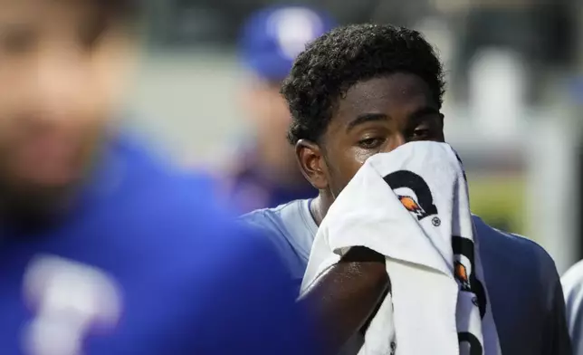 Texas Rangers starting pitcher Kumar Rocker walks in the dugout after facing the Seattle Mariners during the third inning of a baseball game Thursday, Sept. 12, 2024, in Seattle. (AP Photo/Lindsey Wasson)