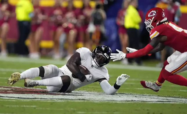 Baltimore Ravens inside linebacker Roquan Smith, left, intercepts a pass as Kansas City Chiefs wide receiver Rashee Rice defends during the first half of an NFL football game Thursday, Sept. 5, 2024, in Kansas City, Mo. (AP Photo/Charlie Riedel)