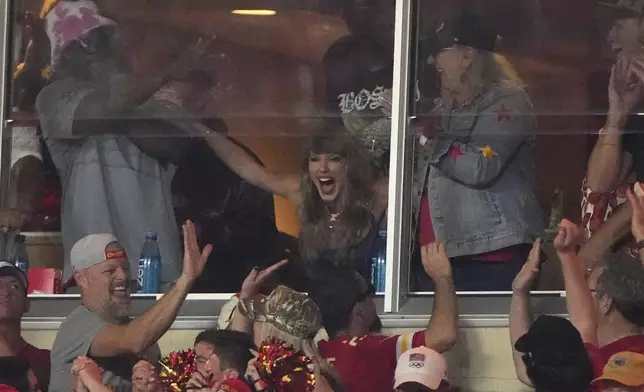 Taylor Swift cheers in a suite during the first half of an NFL football game between the Kansas City Chiefs and the Baltimore Ravens Thursday, Sept. 5, 2024, in Kansas City, Mo. (AP Photo/Charlie Riedel)