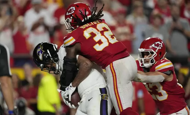 Baltimore Ravens tight end Isaiah Likely, left, catches a pass out of bounds as Kansas City Chiefs linebacker Nick Bolton (32) and linebacker Drue Tranquill (23) defend as time time expires in the second half of an NFL football game Thursday, Sept. 5, 2024, in Kansas City, Mo. The Chiefs won 27-20. (AP Photo/Charlie Riedel)